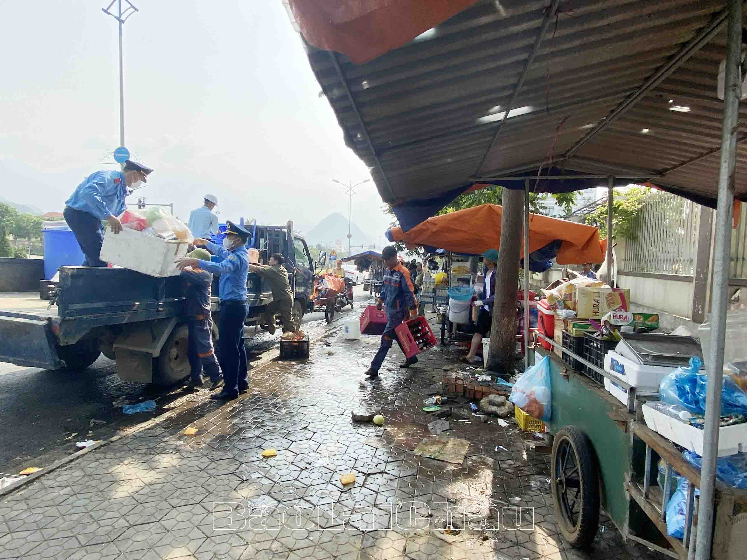 Các lực lượng giúp người dân kinh doanh tại khu vực trước cổng Bệnh viện Đa khoa tỉnh thu dọn hàng hóa.